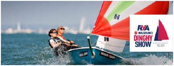 Two people sail a small dinghy with a red and white sail on the water. The RYA Suzuki Dinghy Show logo appears in the right corner of the image.