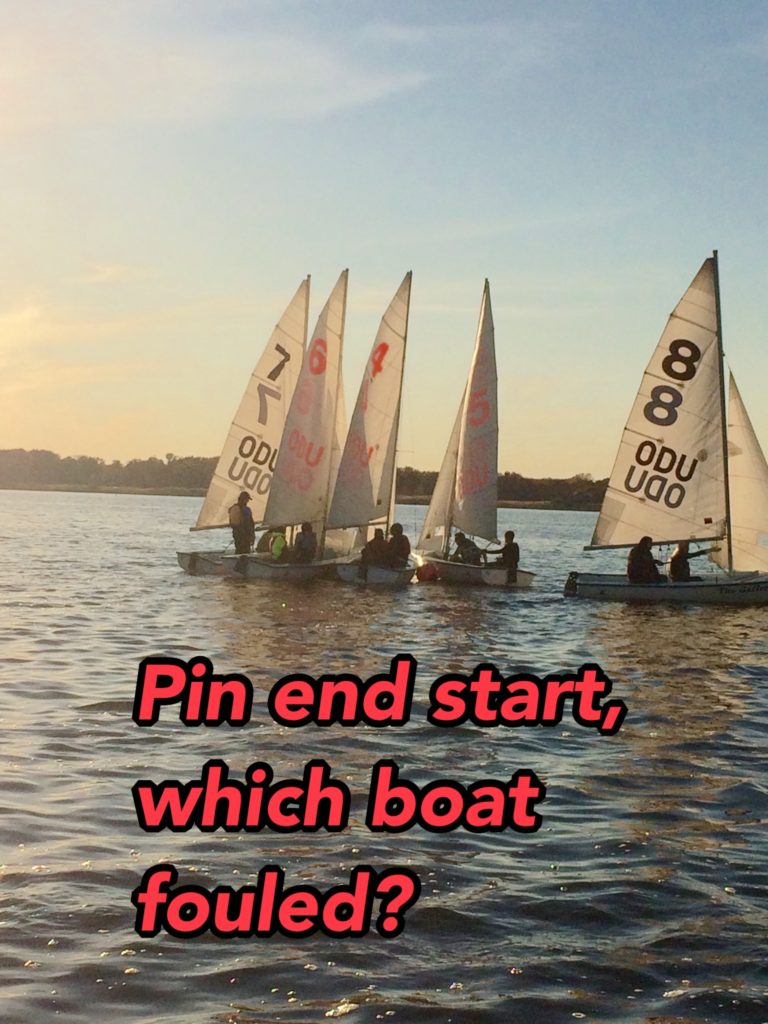 Five small sailboats with numbered sails line up close together on a sunlit lake at the start of a race. Overlaid red text asks, 'Pin end start, which boat fouled?.