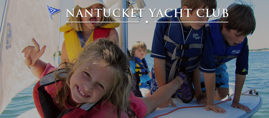 Four children wearing life jackets smile and play on a sailboat in the water on a sunny day. The words 'Nantucket Yacht Club' appear at the top of the image.