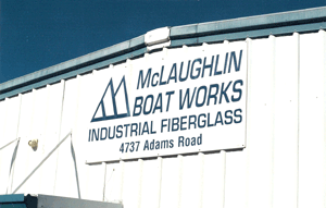 White building with a sign that reads “McLaughlin Boat Works Industrial Fiberglass 4737 Adams Road” in blue letters, alongside a simple logo with two boat-shaped outlines.