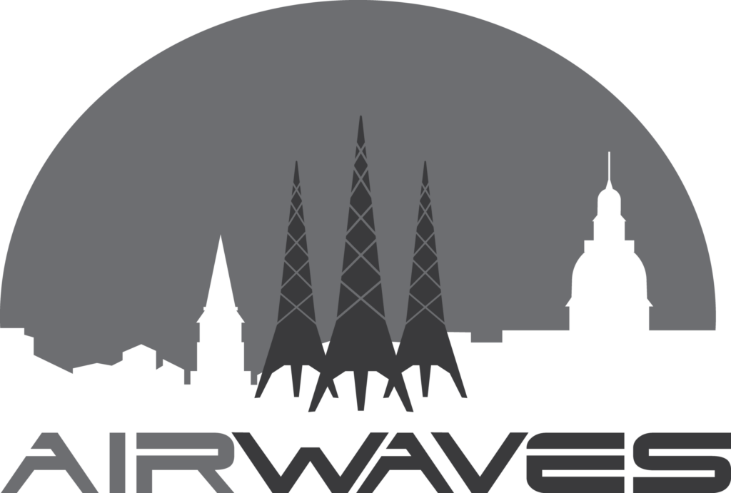 A grayscale logo featuring three radio towers in front of a city skyline with various building silhouettes and a large semi-circle in the background. The word 'AIRWAVES' appears below in bold, modern font.