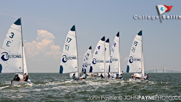 Eight sailboats with numbered sails race on the water under a partly cloudy sky, with a bridge visible in the background. The sails display "Tritons" and "College Sailing" appears in the top right corner.
