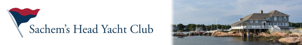 A red and blue flag, the text "Sachem’s Head Yacht Club," and a waterfront clubhouse building with boats and rocks along the shore under a partly cloudy sky.