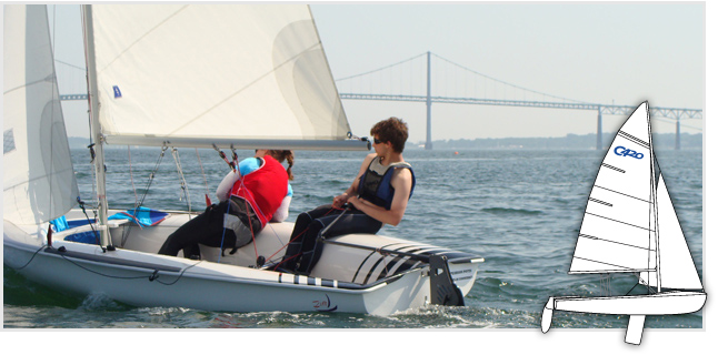 Two people sail a small white dinghy on a calm body of water, with a large suspension bridge visible in the background. An illustrated diagram of the same sailboat appears in the lower right corner.