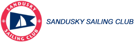 Red circular logo with white text reading "Sandusky Sailing Club" and a blue pennant with a white sailboat inside. To the right, blue italic text reads "SANDUSKY SAILING CLUB.