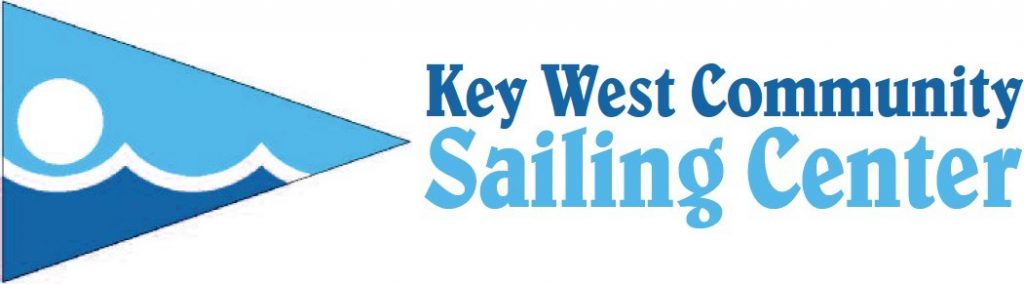 Logo of Key West Community Sailing Center featuring a blue triangular pennant with a white sun over waves, alongside the organization's name in blue text.