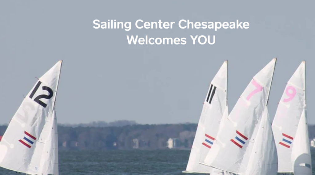 Four white sailboats with visible numbers on their sails are sailing on a body of water, with trees in the distant background. Text above reads: 'Sailing Center Chesapeake Welcomes YOU.