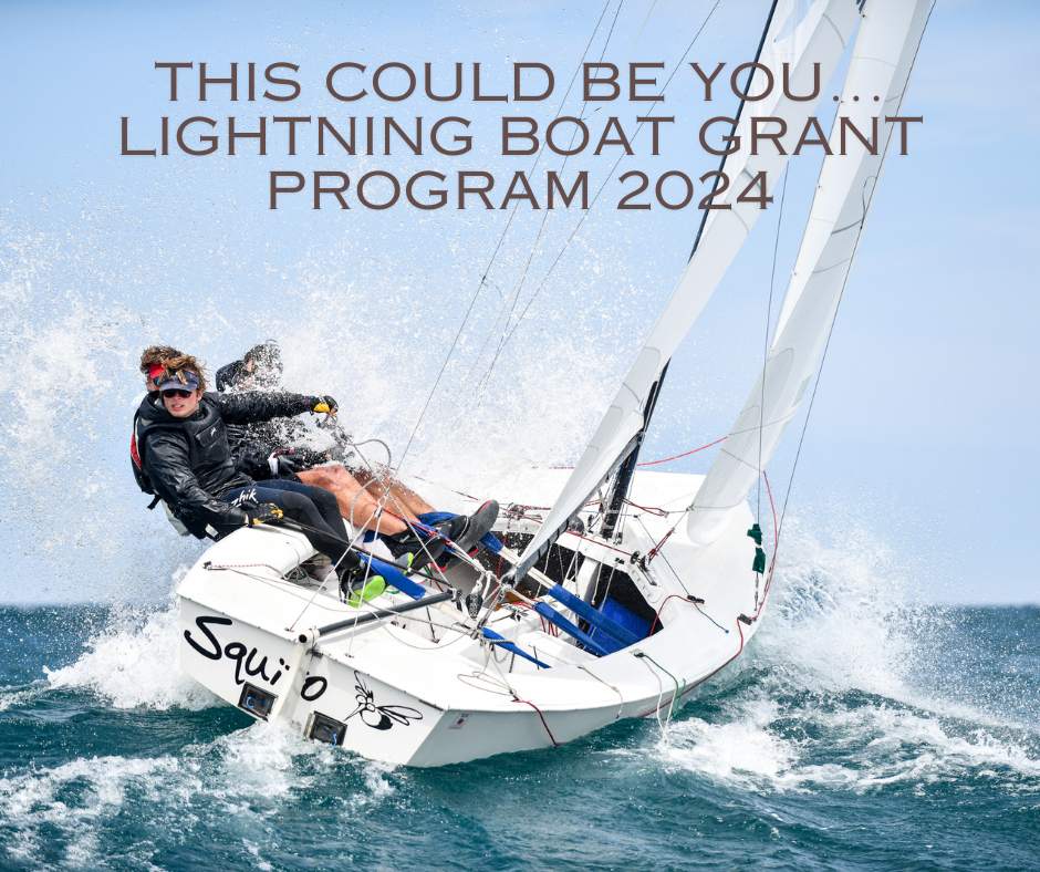 Two people sail a small white sailboat at an angle, cutting through choppy blue water with sea spray flying. Text above reads: 'THIS COULD BE YOU... LIGHTNING BOAT GRANT PROGRAM 2024.
