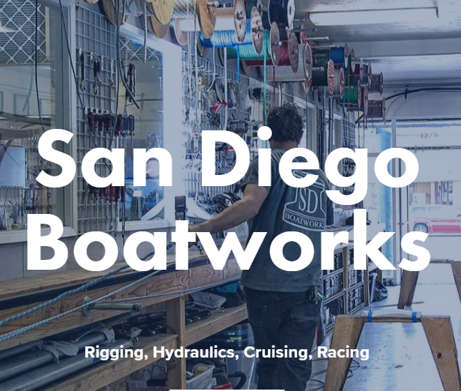 A person works at a bench surrounded by tools, ropes, and boat parts inside a workshop. Large text reads 'San Diego Boatworks' with smaller text below: 'Rigging, Hydraulics, Cruising, Racing.
