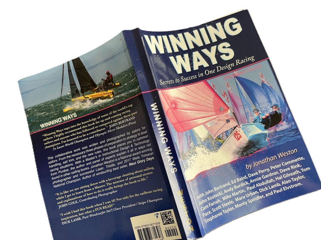 A book titled 'Winning Ways: Secrets to Success in One Design Racing' by Jonathan Weston is shown open, displaying its front and back cover, with images of sailboats racing on the water.