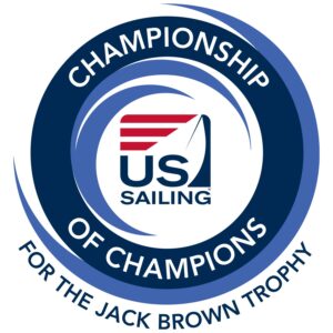 Circular logo with blue swirls, featuring "US Sailing" in the center. Around it, text reads: "Championship of Champions for the Jack Brown Trophy.