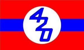 A red flag with a horizontal blue stripe and a white circle in the center. Inside the circle, the blue numbers 